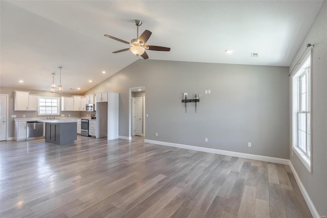 unfurnished living room featuring baseboards, light wood-style flooring, and ceiling fan