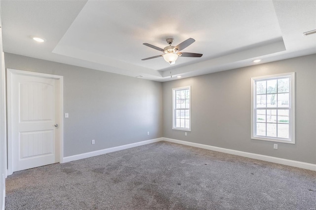 unfurnished room featuring baseboards, a tray ceiling, and ceiling fan