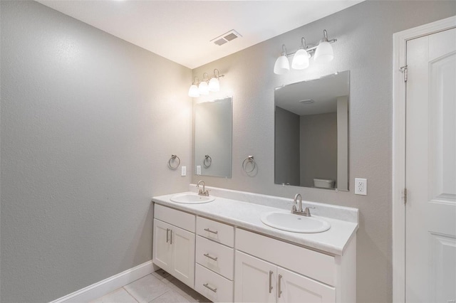 bathroom featuring double vanity, a sink, tile patterned flooring, and visible vents