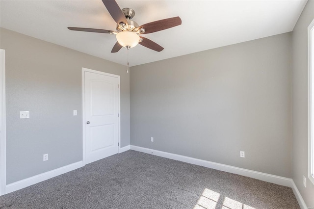 carpeted spare room with baseboards and a ceiling fan