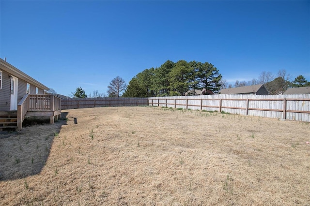 view of yard with a wooden deck and a fenced backyard