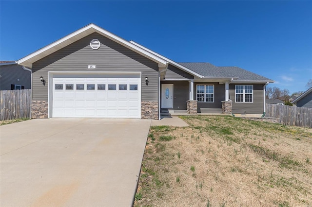 craftsman house featuring a front yard, stone siding, concrete driveway, fence, and a garage