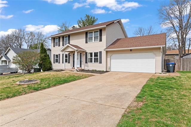 colonial inspired home with driveway, a garage, fence, and a front lawn