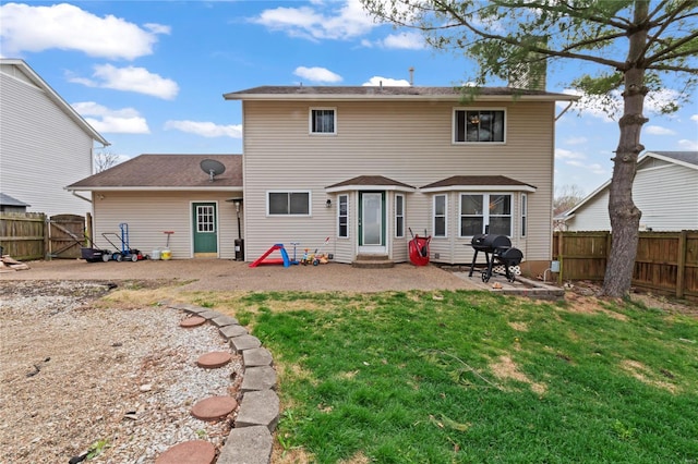 rear view of property featuring a fenced backyard, a lawn, and a patio