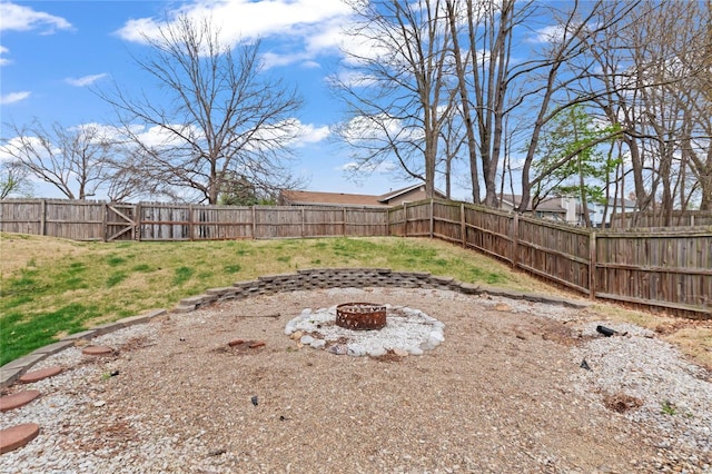 view of yard with a gate, an outdoor fire pit, and a fenced backyard
