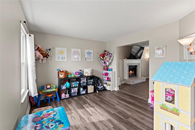 game room with a fireplace and wood finished floors