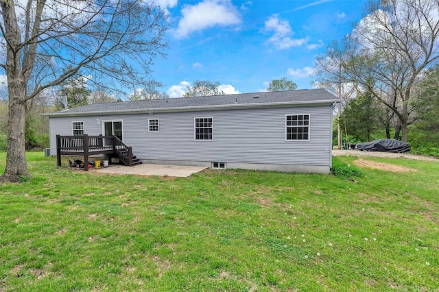 rear view of house with a wooden deck, a yard, and a patio area