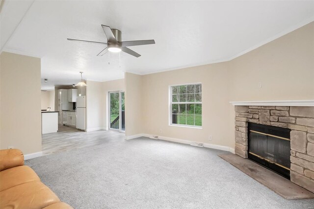 unfurnished living room with baseboards, ornamental molding, light colored carpet, and ceiling fan
