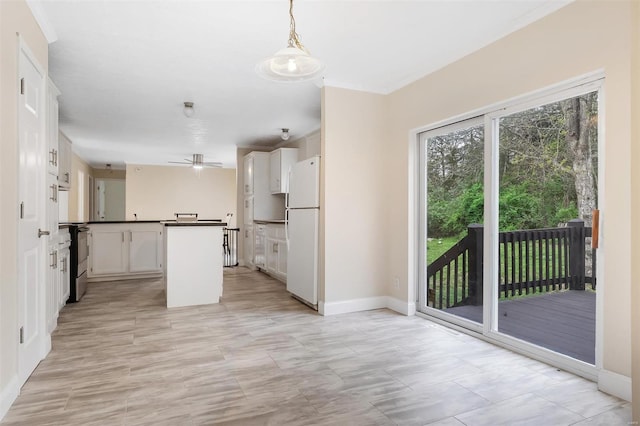kitchen featuring dark countertops, freestanding refrigerator, white cabinetry, and electric stove
