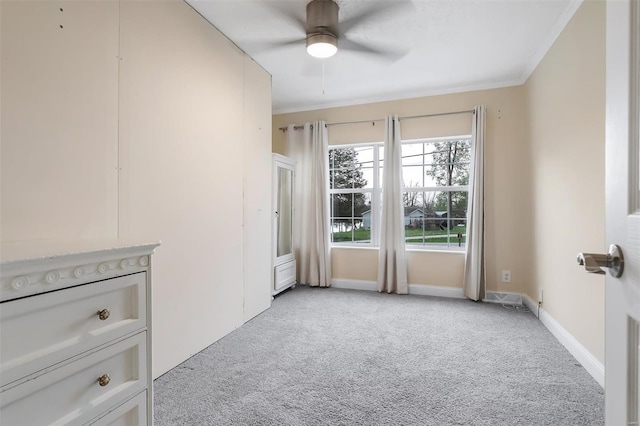 unfurnished room featuring light carpet, baseboards, ornamental molding, and ceiling fan