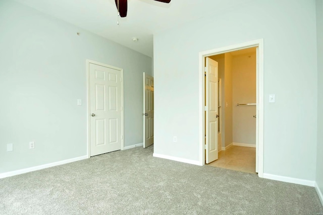 unfurnished bedroom featuring carpet flooring, baseboards, and a ceiling fan