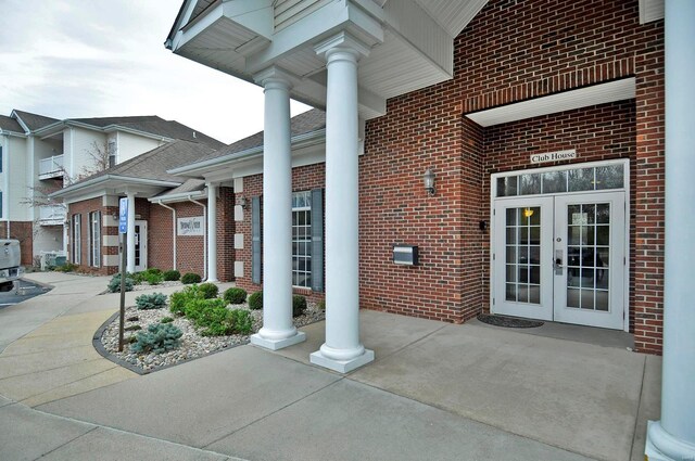 view of exterior entry with brick siding and french doors