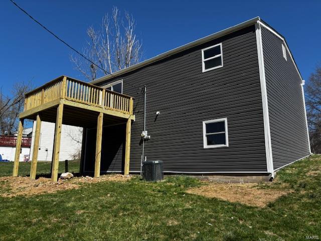 back of house with cooling unit, a lawn, and a deck