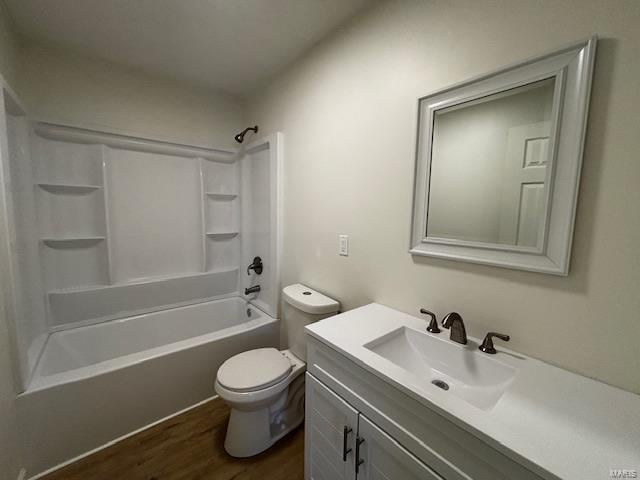 bathroom with washtub / shower combination, toilet, vanity, and wood finished floors