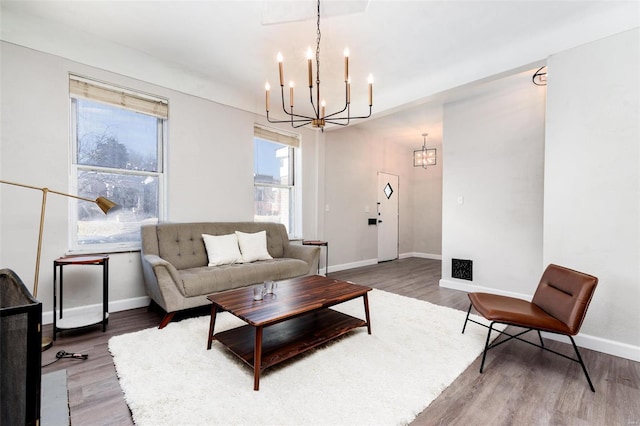 living room featuring light wood-type flooring, baseboards, and a chandelier