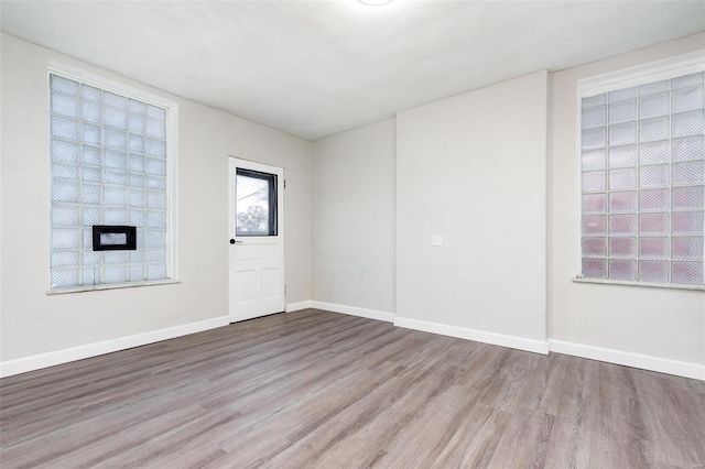 empty room with baseboards and wood finished floors