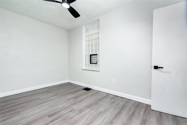 empty room featuring baseboards, a ceiling fan, and wood finished floors