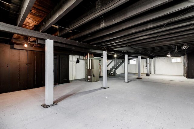 basement with heating unit and stairs