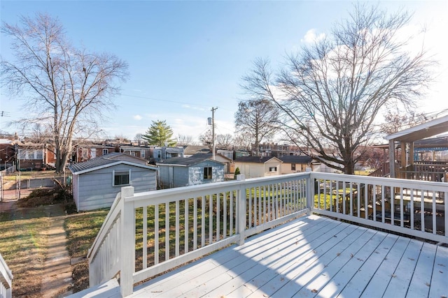 wooden terrace featuring a residential view and an outbuilding