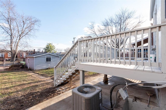 view of patio with stairs, an outbuilding, and central AC unit