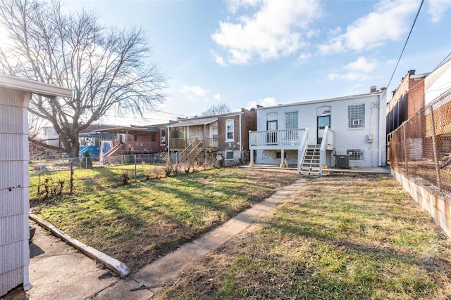 back of property with a wooden deck, a residential view, a lawn, and a fenced backyard