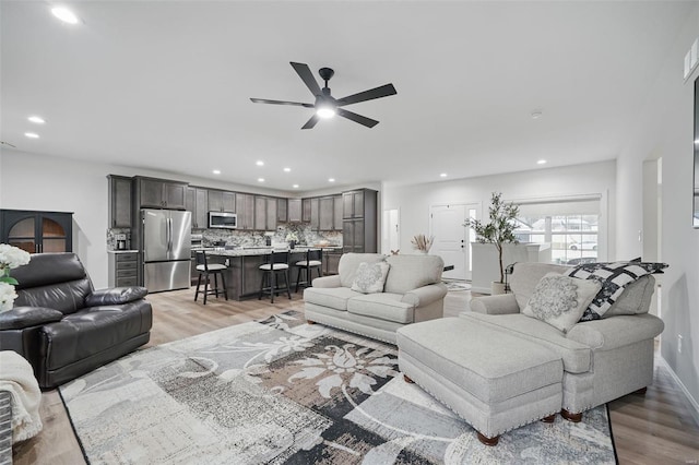 living area featuring ceiling fan, recessed lighting, and light wood-style floors