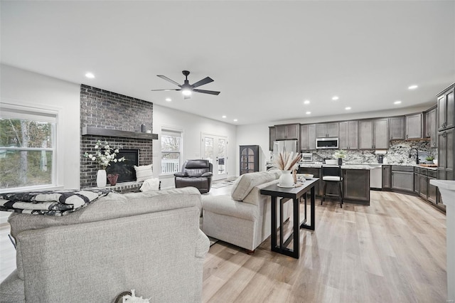 living room featuring light wood finished floors, recessed lighting, and a ceiling fan