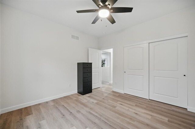 unfurnished bedroom featuring a closet, light wood-style flooring, baseboards, visible vents, and ceiling fan