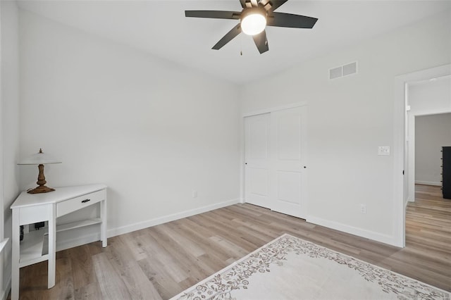 bedroom with baseboards, visible vents, a ceiling fan, and wood finished floors
