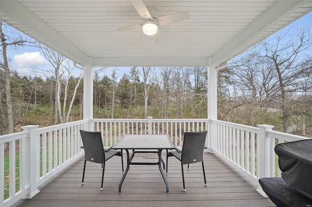 wooden terrace featuring a ceiling fan and outdoor dining space