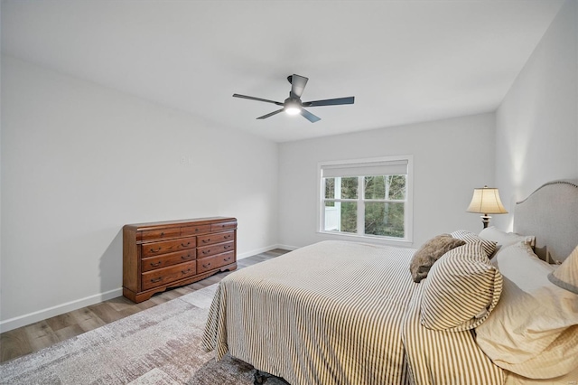 bedroom with baseboards, wood finished floors, and a ceiling fan