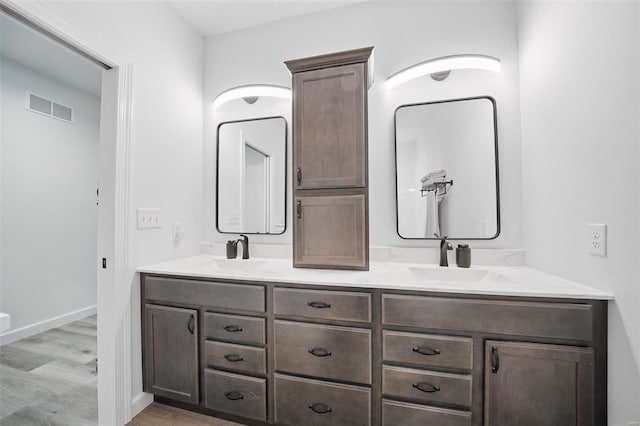 full bathroom with double vanity, visible vents, and a sink