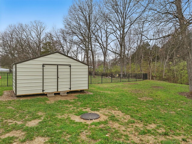 view of yard with an outdoor structure, fence, and a storage shed