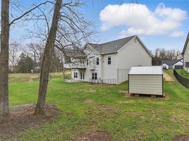 back of house featuring an outbuilding, a shed, fence, a deck, and a yard