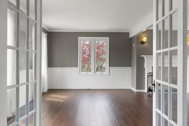 unfurnished room featuring crown molding, french doors, hardwood / wood-style floors, and a fireplace