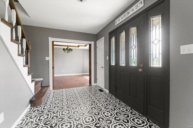 foyer entrance featuring an inviting chandelier, baseboards, and stairway