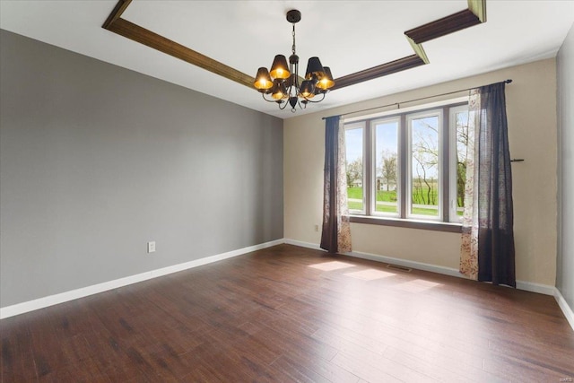 unfurnished room with baseboards, a chandelier, visible vents, a tray ceiling, and wood finished floors