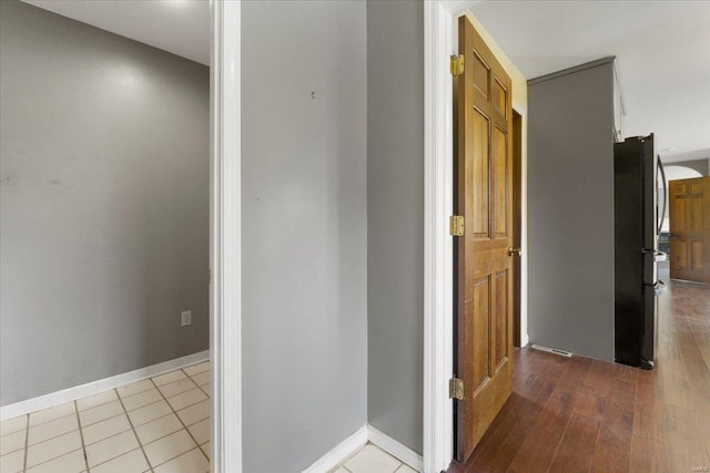 hall with light tile patterned floors and baseboards