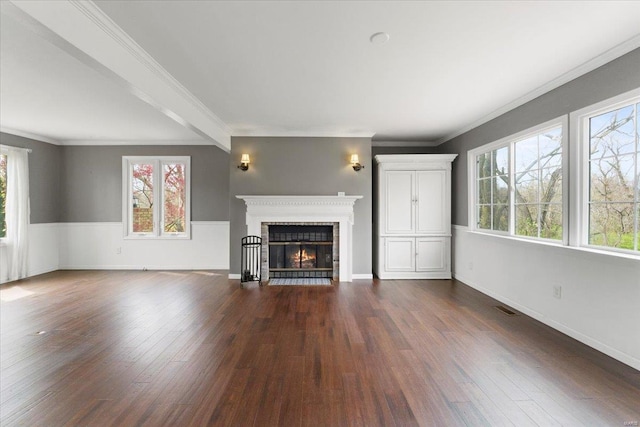 unfurnished living room with crown molding, a fireplace, visible vents, dark wood-style flooring, and baseboards