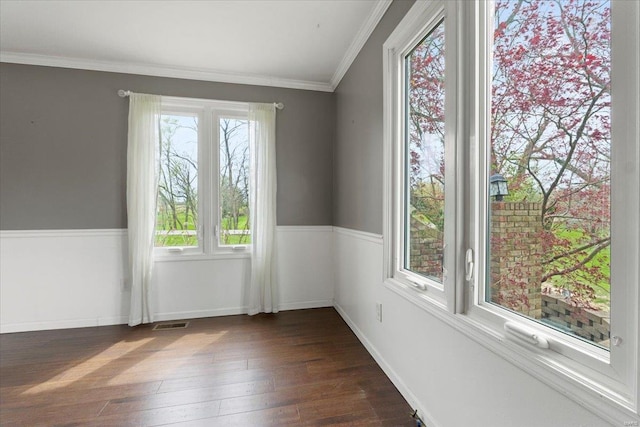 empty room featuring ornamental molding, baseboards, visible vents, and dark wood finished floors
