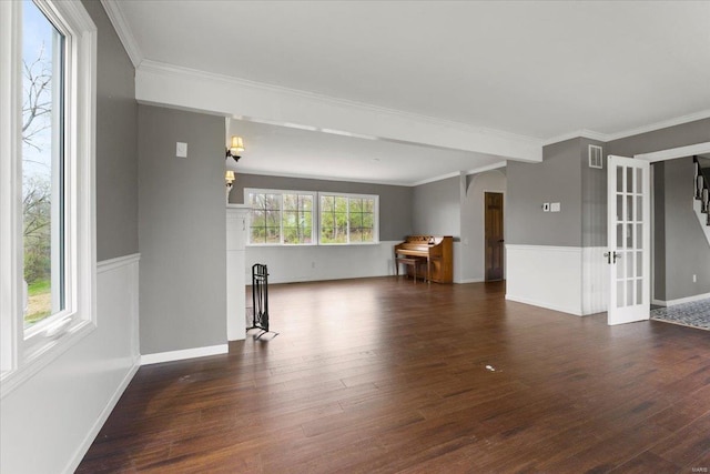 unfurnished living room with dark wood-style flooring, visible vents, crown molding, and a healthy amount of sunlight