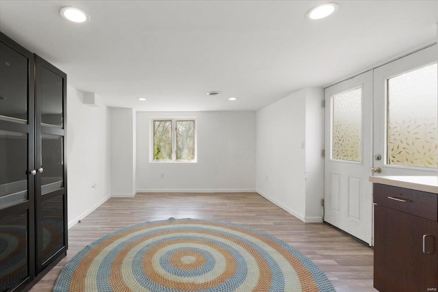 interior space featuring light wood-style floors, baseboards, and recessed lighting