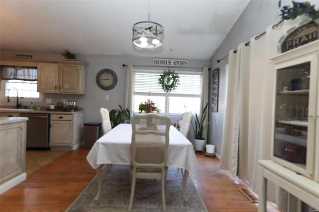 dining space featuring lofted ceiling, a notable chandelier, and light wood-style floors