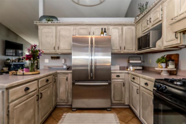 kitchen with a peninsula, light countertops, light tile patterned floors, and high quality fridge