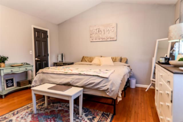 bedroom featuring vaulted ceiling, wood finished floors, and baseboards