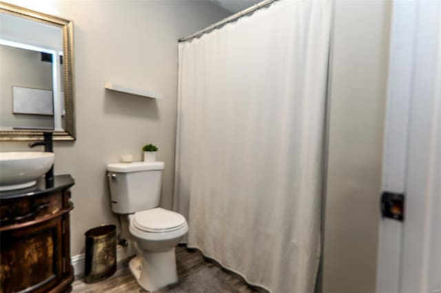 bathroom featuring toilet, a shower with curtain, vanity, and wood finished floors