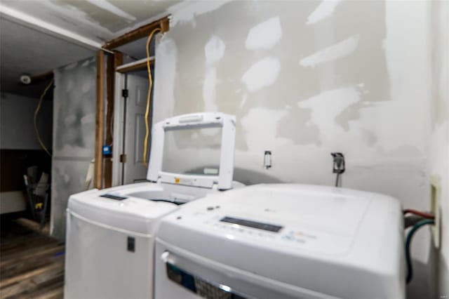 laundry area featuring separate washer and dryer, dark wood-style flooring, and laundry area