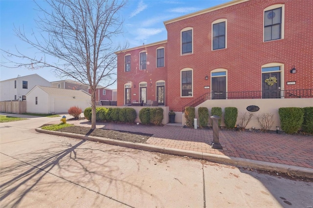 view of property featuring brick siding and fence