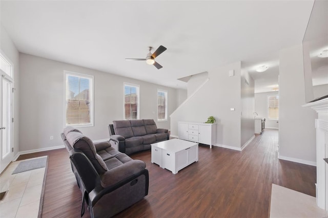 living room with plenty of natural light, dark wood-style floors, ceiling fan, and baseboards