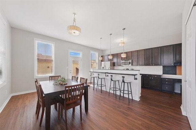 dining space with baseboards and dark wood-style flooring